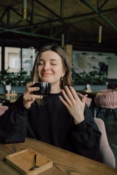 Woman enjoying her cup of tea coffee, hot beverage eyes closed