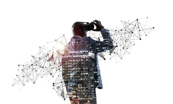 African businessman wearing VR goggles and exploring virtual reality. Black man standing and touching VR headset. Studio photo businessperson in formal wear on white background. Virtual entertainment