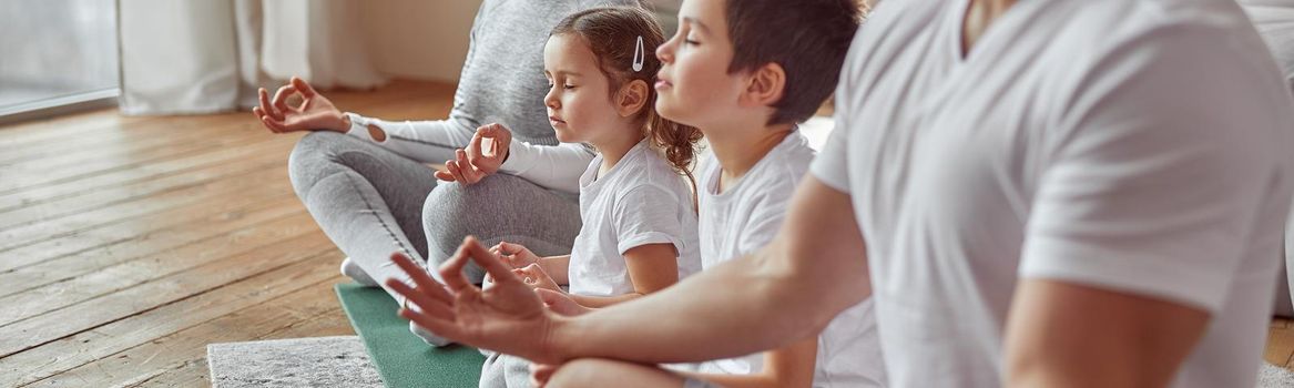 Cropped head of mother and father while they are doing mental practice with son and daughter