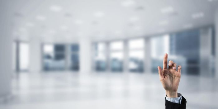 Close of businesswoman hand touching screen with finger and office at background