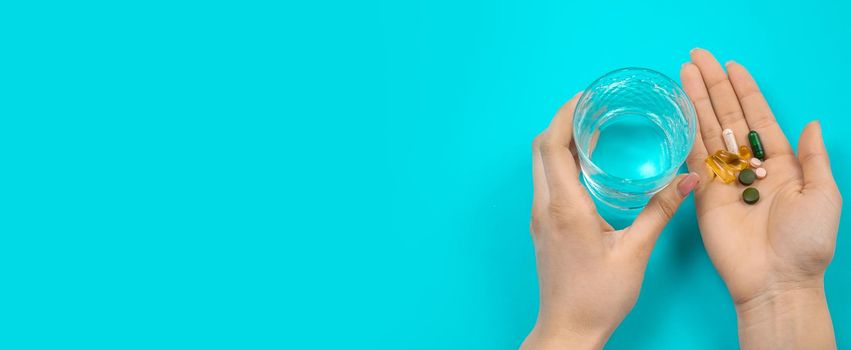 Omega 3 fish oil capsules spilling out of a bottle on a blue background.