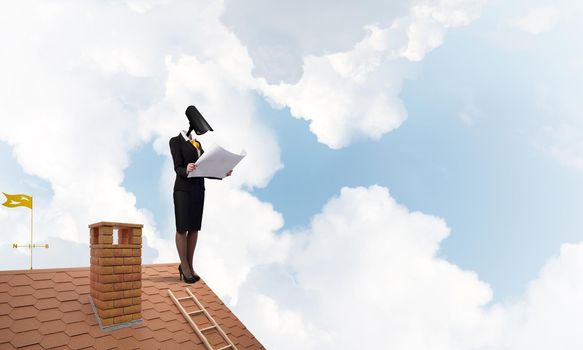 Faceless businesswoman with camera zoom instead of head standing on house roof