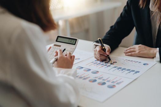 Close up Businessman and partner using calculator and laptop for calaulating finance, tax, accounting, statistics and analytic research concept.