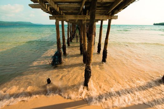 View of the waves and sea under a wooden boardwalk in Koh Rong Samloen in Cambodia