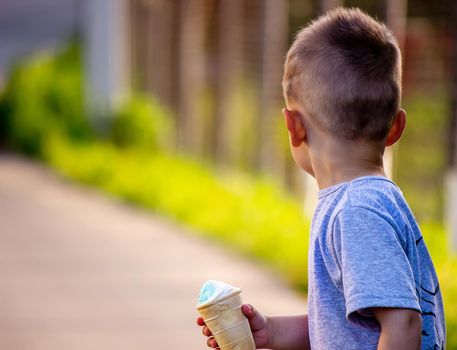 child eats ice cream in nature, ice cream in a cup. Nature. Selective focus