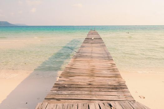 Scenic view of a wooden boardwalk leading to the beach of Koh Rong Samloen Island, a popular summer getaway destination in Cambodia