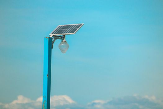 A solar-powered lamp post against the blue sky showing renewable energy alternative and sustainable lifestyle