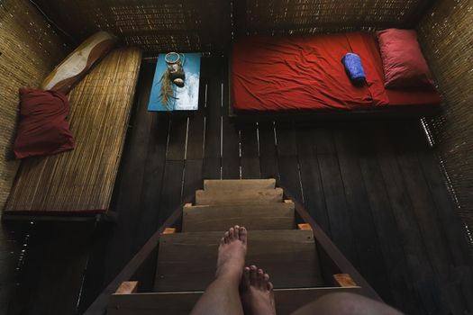 Person looking down at a dark empty wooden cabin room