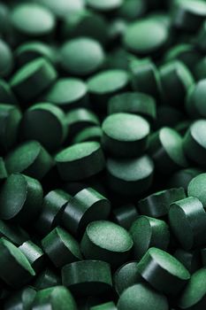 Green tablets from spirulina vegetarian dietary supplement as a full-screen texture