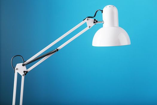 White table office lamp on blue background with space for text and idea concept