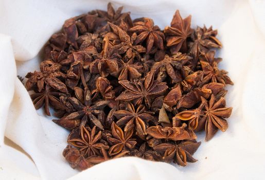 Star anise in a white cloth on display at a market stall