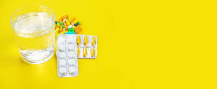 medical supplies on a yellow background, pills water treatment mask virus.