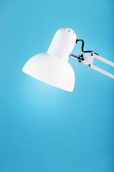 Office table lamp on blue background with space for text and idea concept