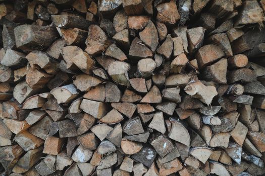 Close up stack of dry firewood oak wooden logs, chopped, split and organized in a pile for winter fuel stock, low angle
