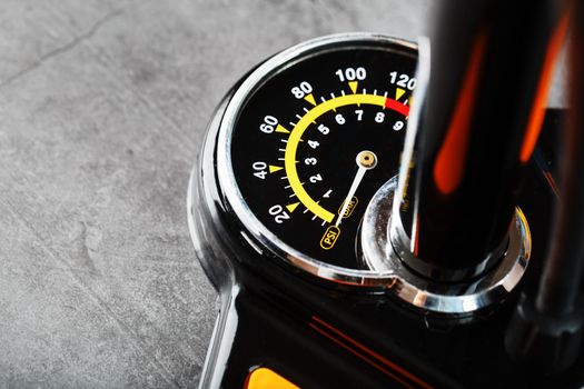 Air pump manometer for monitoring tire pressure on a dark background with free space