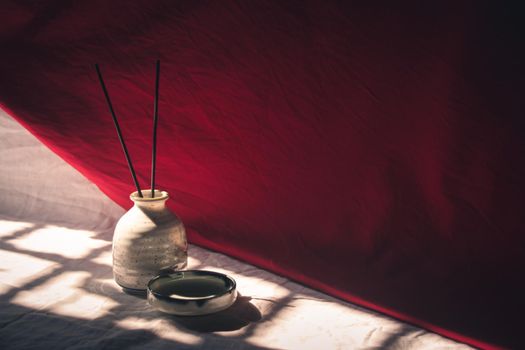 Light and shadows cast on ceramic incense holder showing the concept of mindfulness, tranquility and life balance