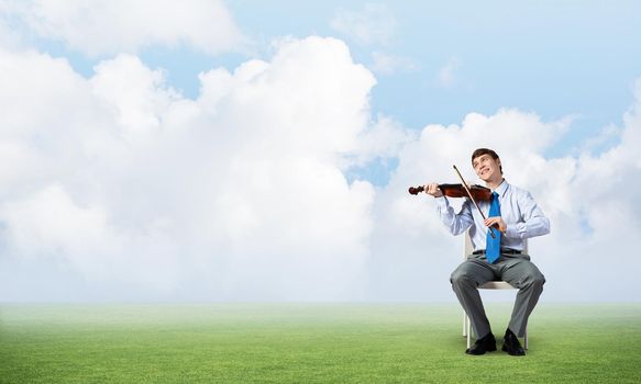 young businessman is engaged in music, meditation and a serene field around