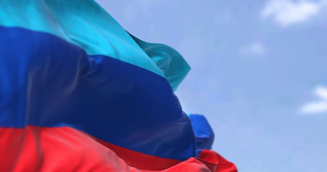 Detail of the national flag of Luhansk People's Republic waving in the wind on a clear day. Luhansk People's Republic is a self-proclaimed breakaway state located within Ukraine. Selective focus.