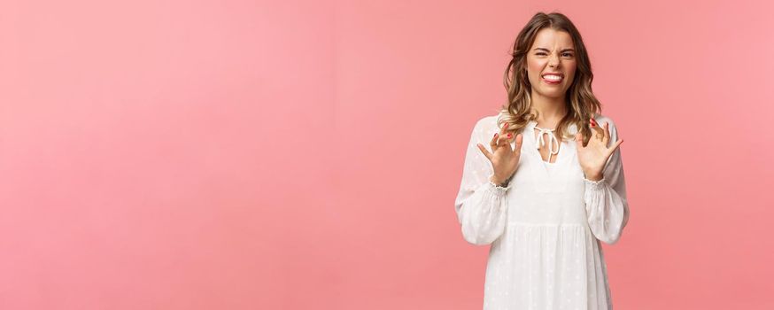 Portrait of girl cringe as telling friend disgusting awful story of her date with guy, show tongue grimacing and press hands to body as feeling discomfort and aversion, stand pink background.