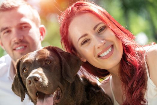 A couple and their dog in the park. Spending time with friends