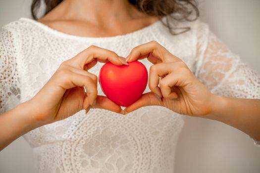 Hands holding red heart, healthcare, love, organ donation, mindfulness, wellbeing, family insurance and CSR concept, world heart day, world health day, national organ donor day.