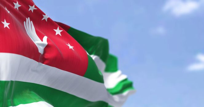Detail of the national flag of Abkhazia waving in the wind on a clear day. Abkhazia is a de facto state in the South Caucasus. Selective focus.