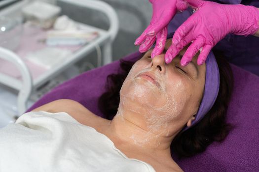 In the first stage, the beautician applies a special gel to the entire face of the client and washes it off with her hands.