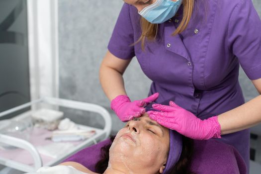 In the first stage, the beautician applies a special gel to the entire face of the client and washes it off with her hands.
