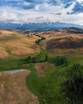 Kurai steppe and Chuya river on North-Chui ridge mountains background. Altai mountains, Russia. Aerial drone panoramic picture.