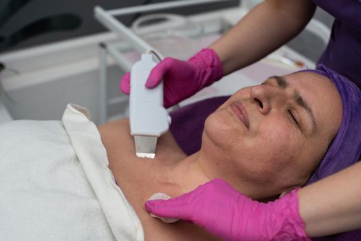 Cavitation device. The beautician gently guides the ultrasound device over the client's face to exfoliate the epidermis.