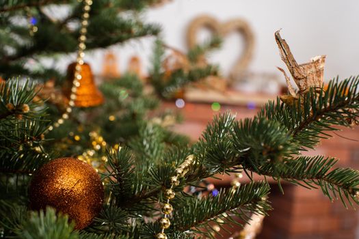 A shiny ornament in the shape of a round Christmas ball attached to a Christmas tree on a Christmas background with cork lights.