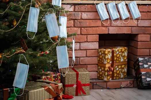 Gifts for the holidays lie under a decorated spruce tree in the large living room of the house. Family holidays despite the global COVID-19 viral disease.