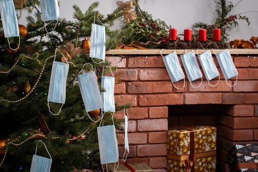 Gifts for the holidays lie under a decorated spruce tree in the large living room of the house. Family holidays despite the global COVID-19 viral disease.