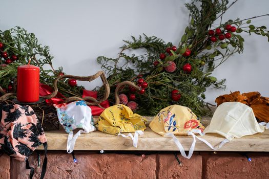 The fireplace is decorated with green coniferous branches and colorful protective masks in case you need to wear it during Christmas.