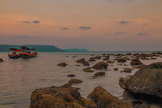Wide angle view of khmer fishing boats on the rocky beach of Koh Rong Island in Cambodia