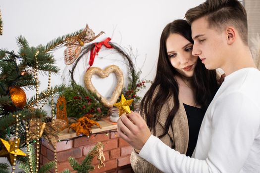 The bride and groom will continue to decorate the Christmas tree. Decoration of a Christmas tree for Christmas in December.