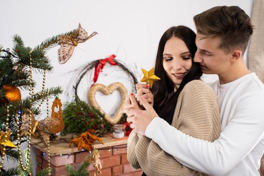 The bride and groom will continue to decorate the Christmas tree. Decoration of a Christmas tree for Christmas in December.