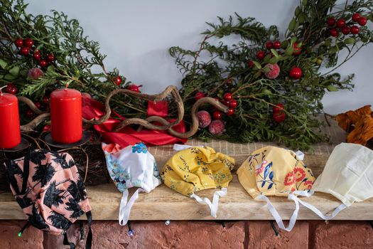 The fireplace is decorated with green coniferous branches and colorful protective masks in case you need to wear it during Christmas.