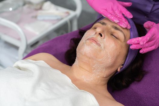 In the first stage, the beautician applies a special gel to the entire face of the client and washes it off with her hands.