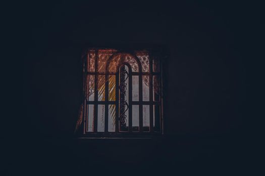 Light coming from a window in a dark and spooky room showing the concept of Halloween