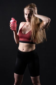 Spotrsman in hand her a shaker holds pink girl in black background shaker pink black caucasian, from female fit in young for trainer isolated, beautiful people. Sweat weight bodybuilder