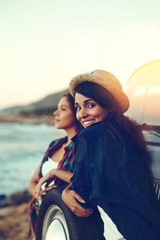 Shot of two young friends stopping at the beach during their roadtrip.