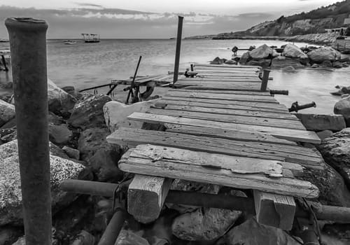 Old wooden pier at the harbor. Black and white. Horizontal view