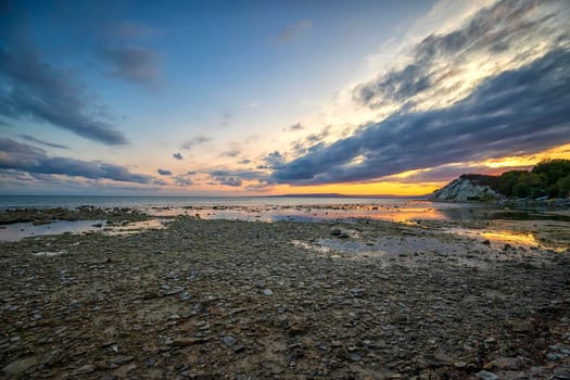 Exciting autumn sunset. Beauty sea rocky coast and colorful sky