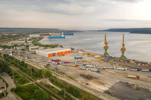 Trucks and port cranes ready to load from cargo ships. Horizontal view