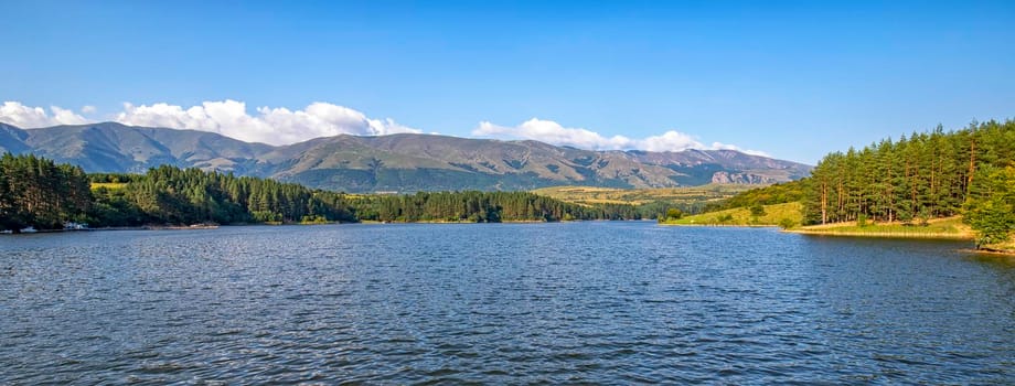 Banner of relaxing mountain landscape at the lake with calm water, forest and beauty sky