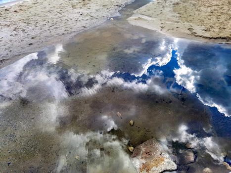 Beauty sky reflection in the water near sea sand 