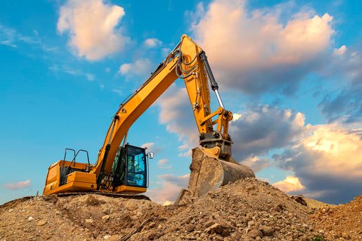 A stopping yellow excavator at stunning fluffy clouds