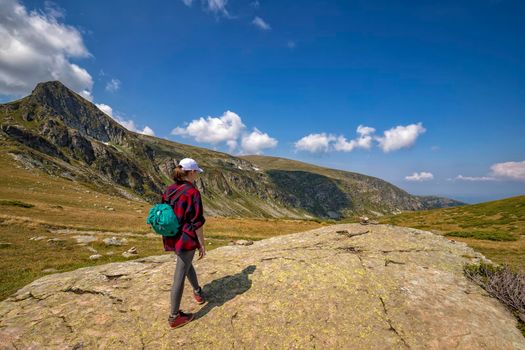 A young girl enjoys a beautiful view. Hiking in the mountains.