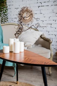 white candles on wooden coffee table in cozy living room interior